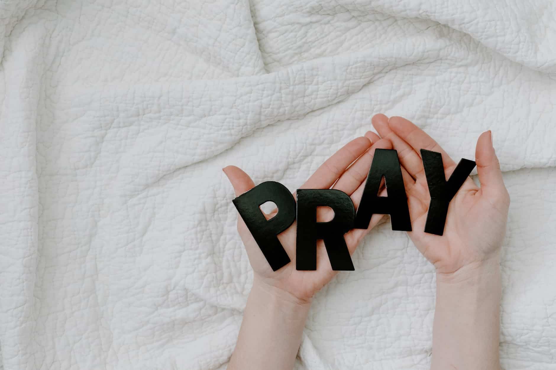 a person holding a black letters that say pray. prayer for a new week blog post
