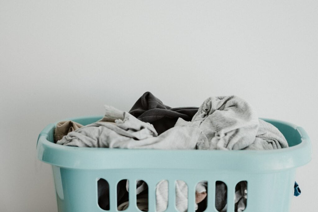 white textile on blue plastic laundry basket, daily cleaning schedule