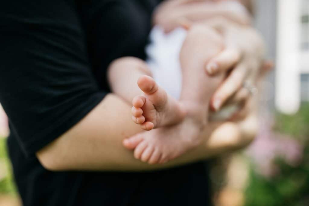 person carrying baby on arms, breastfeeding