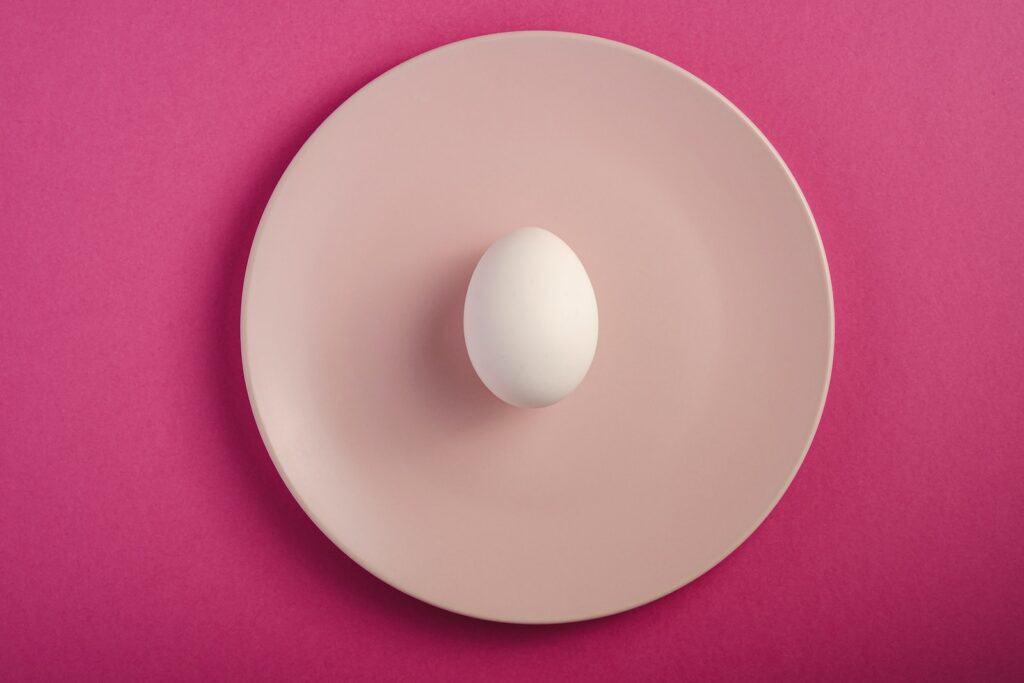 white round plate on pink textile egg white cervical mucus