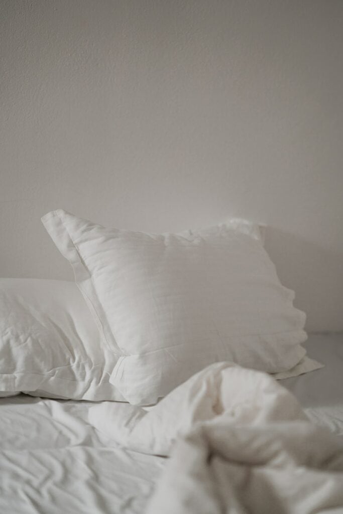 have fatigue jump into white bed pillow against white wall