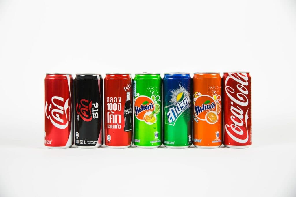 seven assorted-brand soda cans, sugary drinks