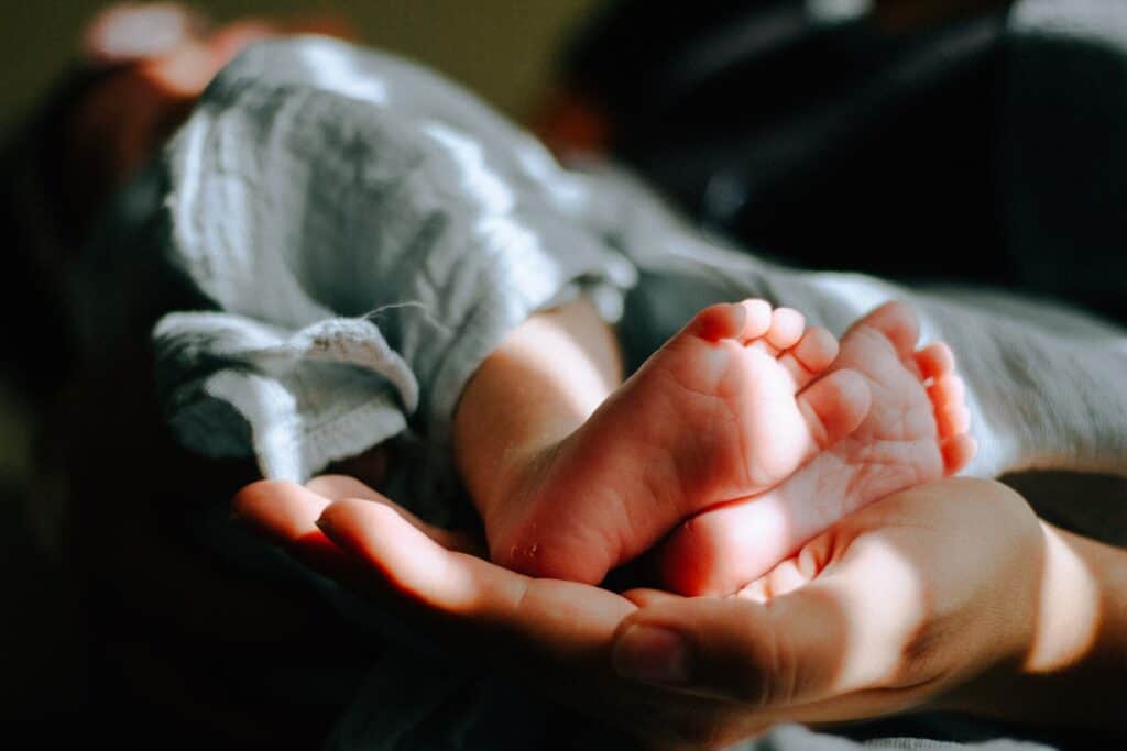 person holding baby feet, rare baby names boys