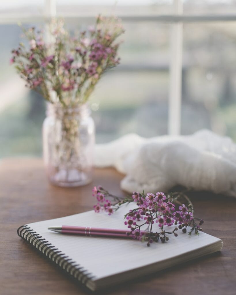 memorize bible verses. shallow focus photo of purple flowers on white spiral notebook